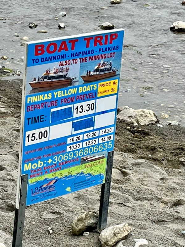 Informační tabule s jízdním řádem lodí na pláž Preveli z letoviska Plakias na jižní Krétě