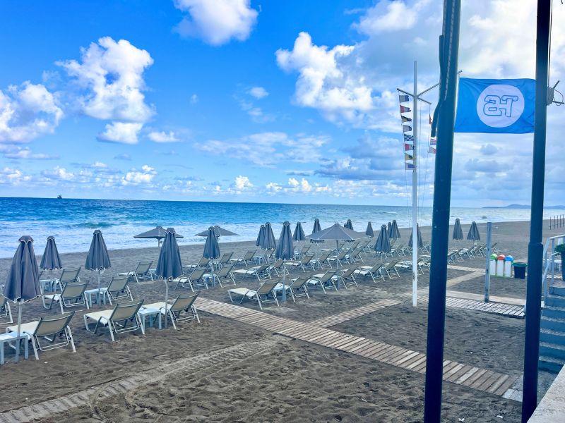 Písečná pláž Atlantis Beach Hotelu v Rethymnu na Krétě s lehátky pro hotelové hosty.