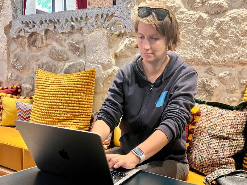 Digitální nomádka pracující na notebooku v recepci Avli Lounge Apartments v historickém Rethymnu