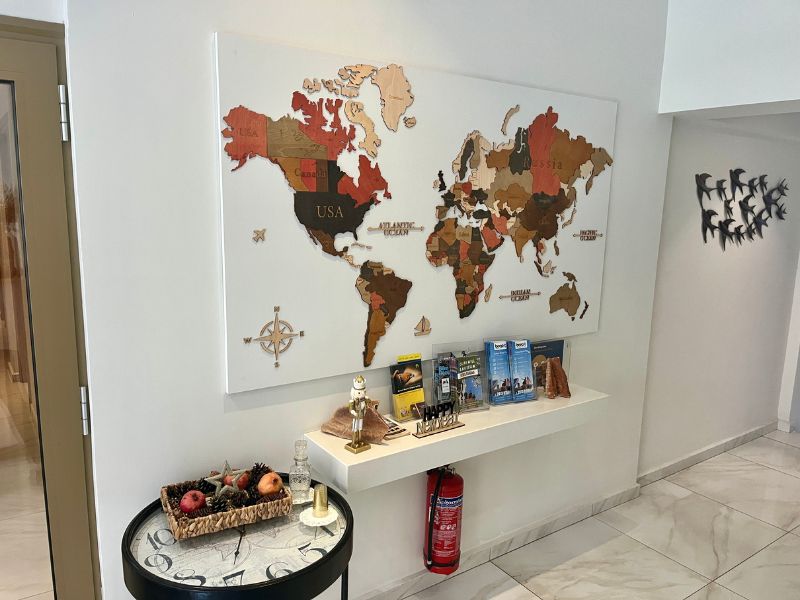 Vstupní prostor hotelu Marvel Deluxe Rooms s mapou světa a tipy na výlety v okolí Heraklionu